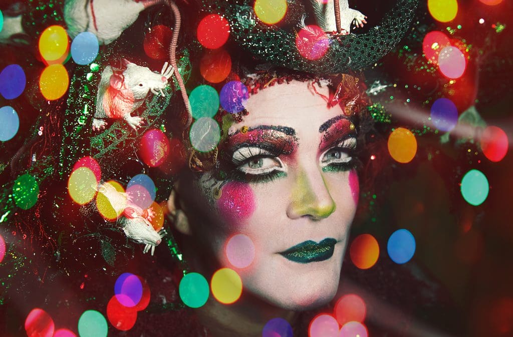 Taylor Mac closeup with Holiday lights